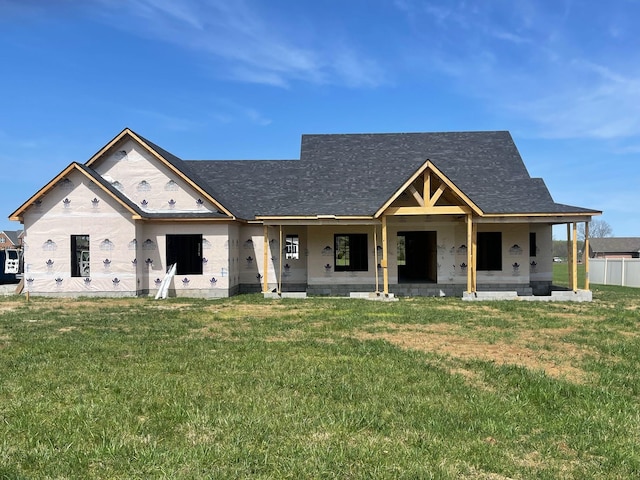 view of front of home with a front lawn, roof with shingles, and a patio area