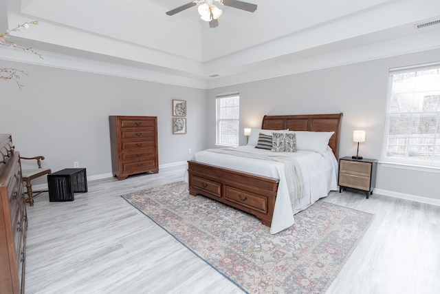 bedroom featuring crown molding, a ceiling fan, light wood finished floors, baseboards, and visible vents