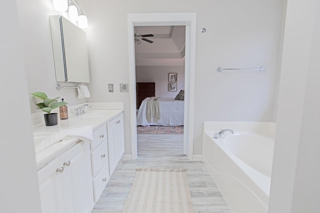 ensuite bathroom with vanity, ensuite bath, a garden tub, a ceiling fan, and wood finished floors