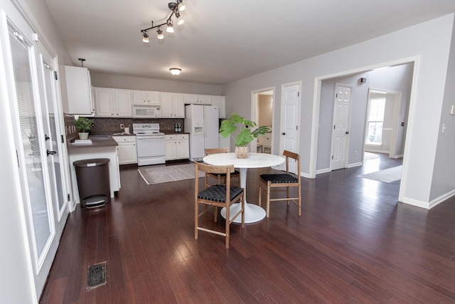 dining space featuring dark wood-type flooring, baseboards, and visible vents