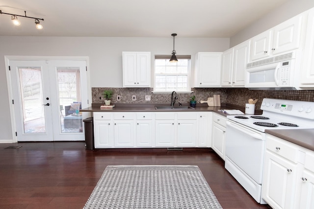 kitchen featuring backsplash, dark wood-style flooring, a sink, and white appliances
