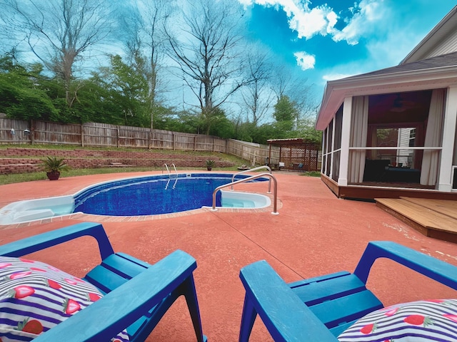 view of swimming pool featuring a patio, a sunroom, a fenced in pool, and a fenced backyard