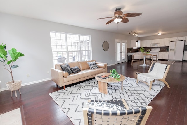 living area featuring a ceiling fan, dark wood-style floors, and baseboards