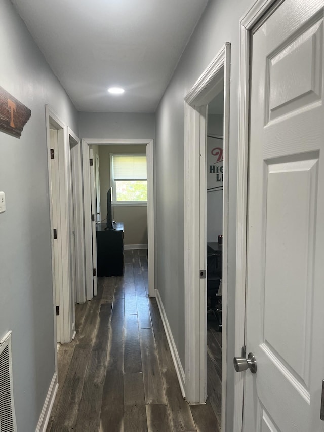 corridor featuring dark wood-style floors, baseboards, and visible vents