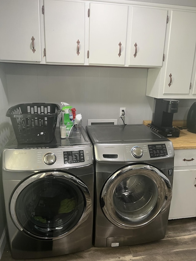 laundry room with washer and dryer, dark wood-type flooring, and cabinet space