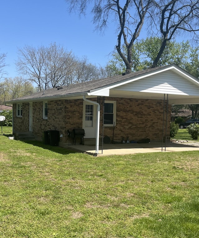back of property with brick siding and a yard