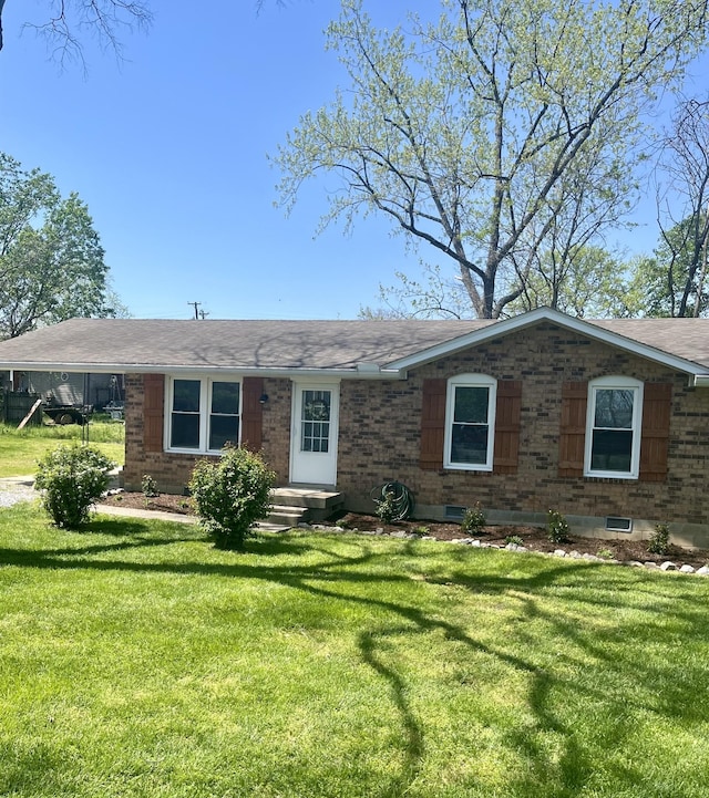 ranch-style home with a front yard and brick siding