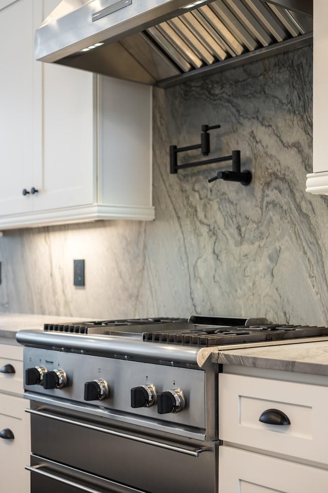 720 Valhalla Ln, Brentwood, TN 37027 - kitchen with tasteful backsplash, white cabinets, exhaust hood, light countertops, and range
