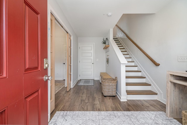 entrance foyer featuring stairway, baseboards, and wood finished floors