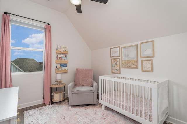 bedroom with a crib, ceiling fan, baseboards, and lofted ceiling
