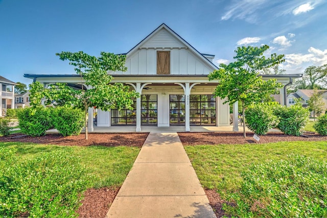 back of house featuring french doors, board and batten siding, and a lawn