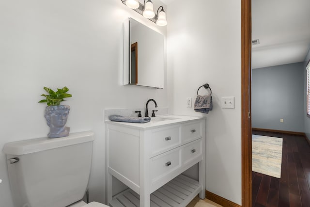 1737 Bratton Ln, Williamsport, TN 38487 - half bath with wood finished floors, toilet, vanity, baseboards, and visible vents