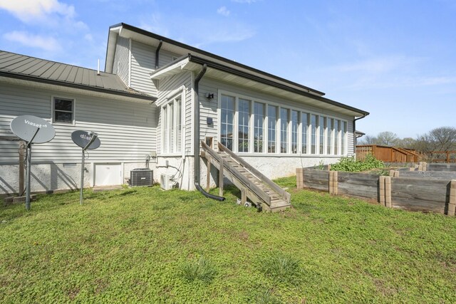 1737 Bratton Ln, Williamsport, TN 38487 - back of house featuring a yard, fence, metal roof, central AC, and a vegetable garden