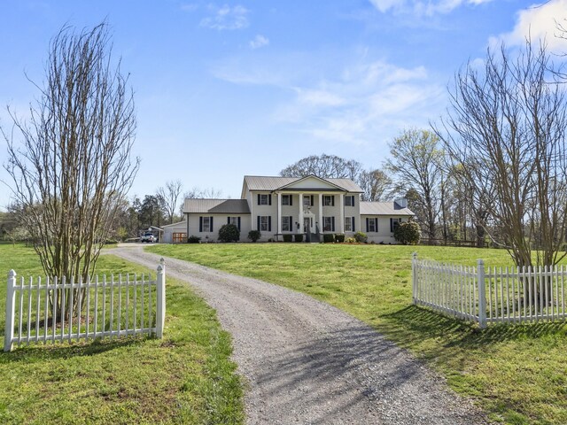 1737 Bratton Ln, Williamsport, TN 38487 - neoclassical home with metal roof, a front lawn, dirt driveway, and fence