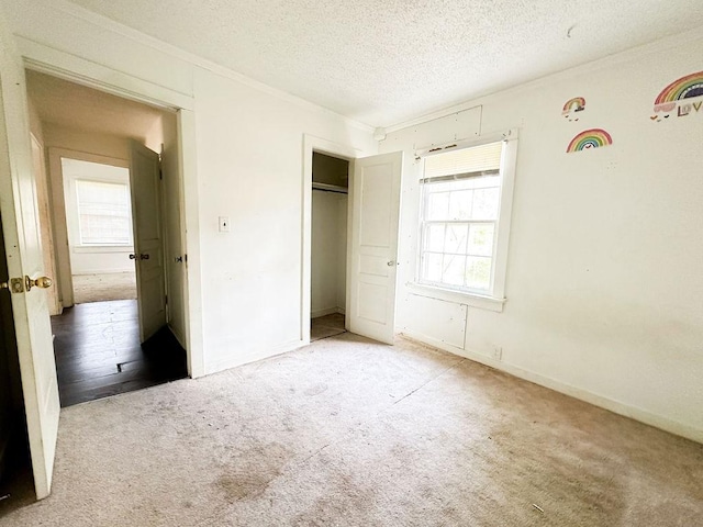unfurnished bedroom featuring carpet flooring, crown molding, and multiple windows