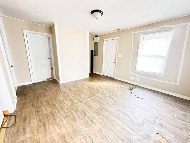 interior space with visible vents, baseboards, wood finished floors, and a textured ceiling
