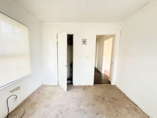 spare room featuring carpet floors, a wealth of natural light, and baseboards