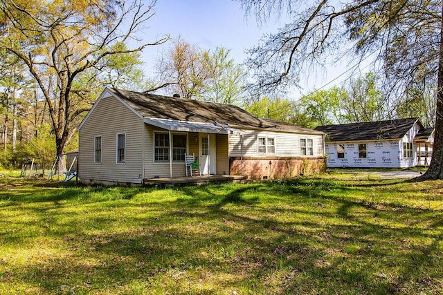 rear view of property featuring a lawn
