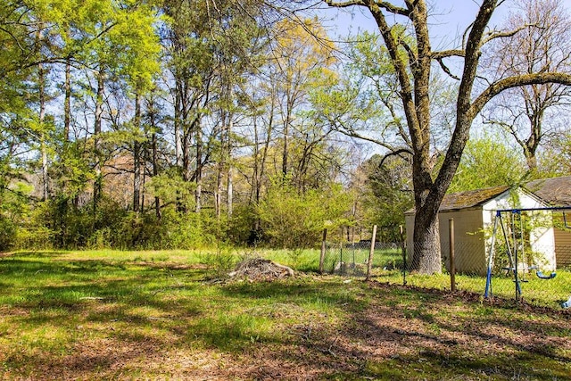 view of yard with an outdoor structure, a storage shed, and fence