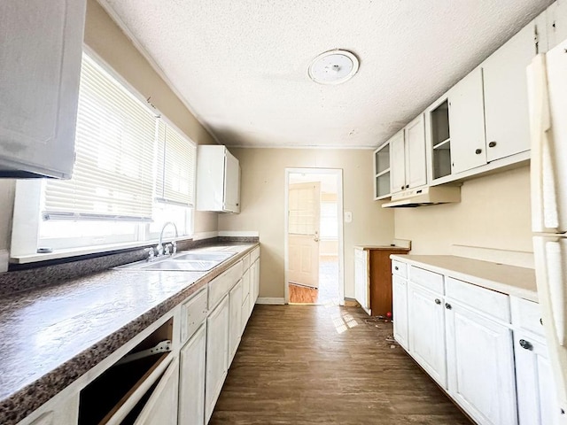 kitchen with a sink, a textured ceiling, white cabinets, dark wood-style flooring, and freestanding refrigerator