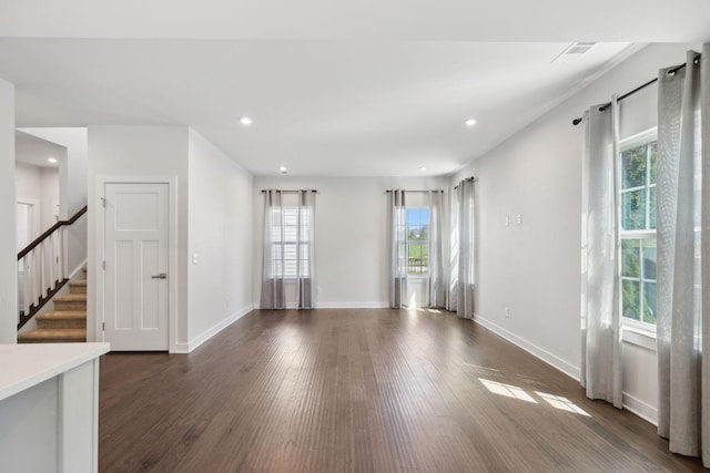 unfurnished room featuring recessed lighting, baseboards, dark wood-style floors, and stairway