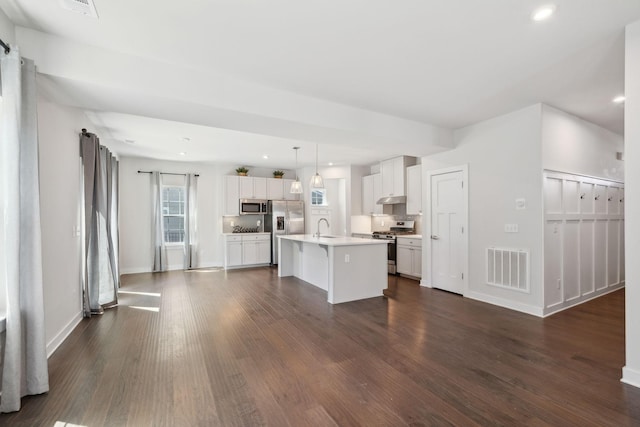 kitchen with visible vents, a sink, dark wood finished floors, under cabinet range hood, and stainless steel appliances