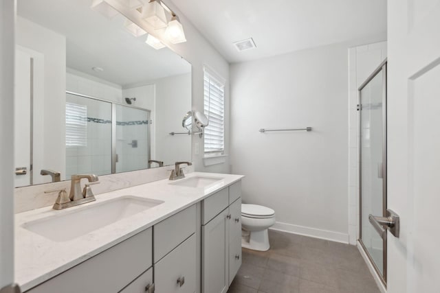 bathroom with toilet, double vanity, a sink, and a stall shower
