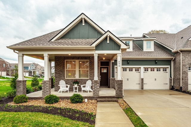 craftsman house featuring concrete driveway, covered porch, a garage, and roof with shingles