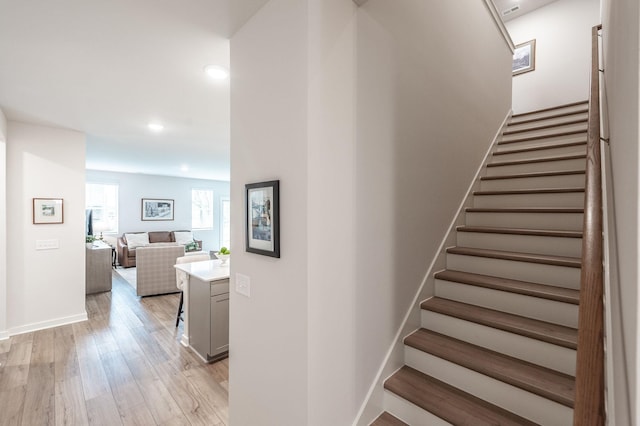 stairs featuring baseboards, wood finished floors, and recessed lighting
