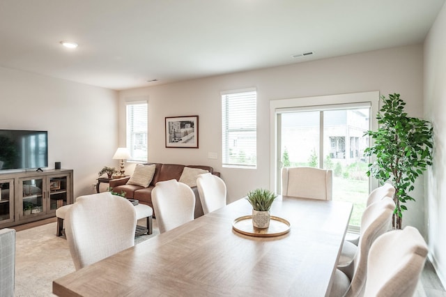 dining space featuring light carpet and visible vents