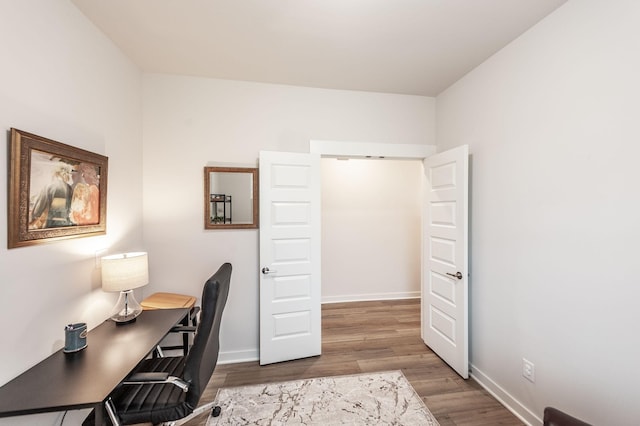home office with baseboards and wood finished floors
