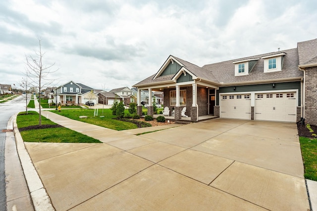 view of front facade with a front yard, concrete driveway, a garage, a residential view, and a porch