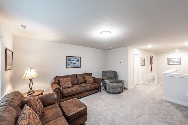 living room with baseboards, visible vents, and carpet