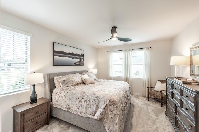 bedroom with a ceiling fan, light colored carpet, and visible vents