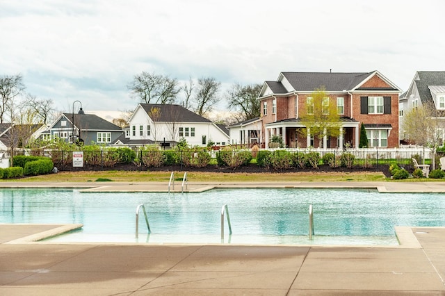 community pool with a residential view and fence