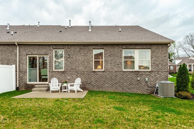 rear view of property featuring brick siding, a yard, and a patio