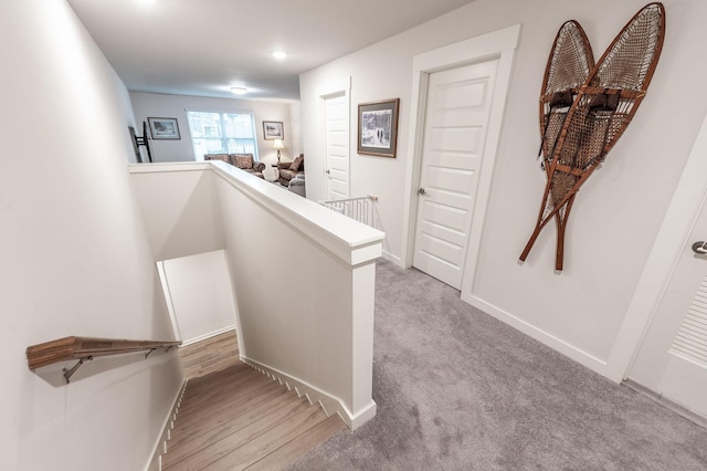 staircase featuring baseboards and carpet