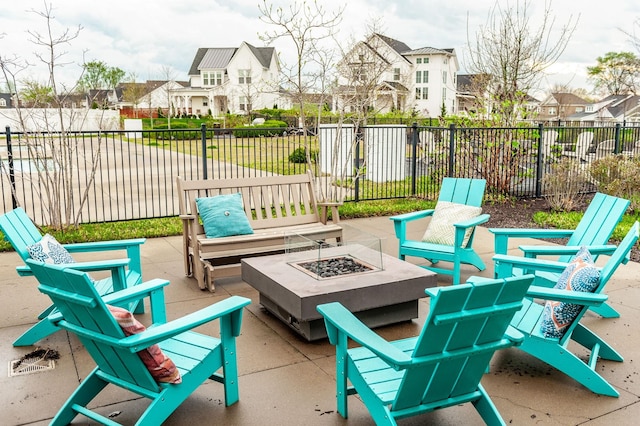 view of patio featuring a residential view, a fire pit, and fence