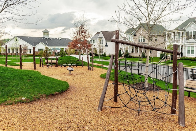 view of community with a lawn, fence, playground community, and a residential view