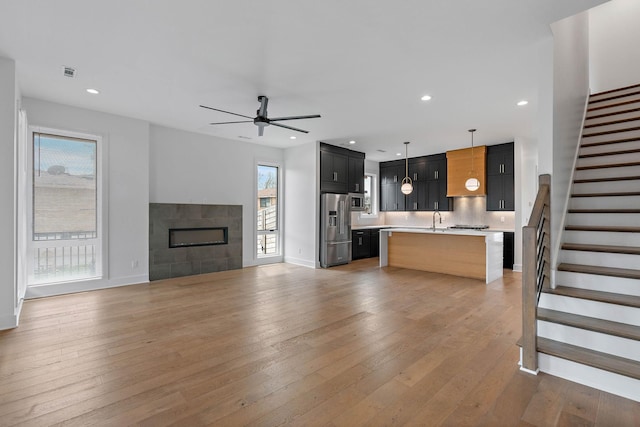 807 32nd Ave N Unit A, Nashville, TN 37209 - unfurnished living room featuring stairs, a healthy amount of sunlight, a ceiling fan, and light wood finished floors