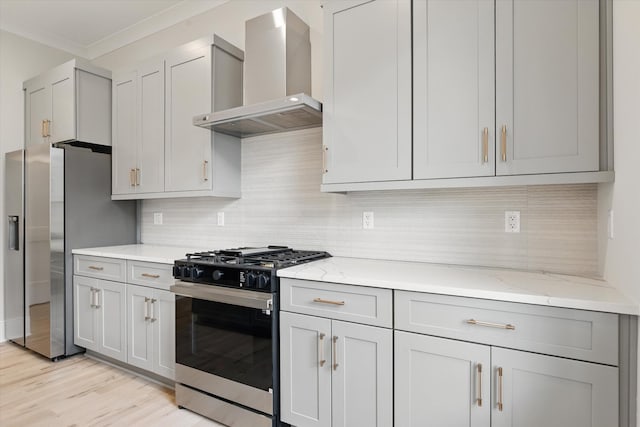 kitchen with tasteful backsplash, ornamental molding, light stone counters, wall chimney range hood, and appliances with stainless steel finishes