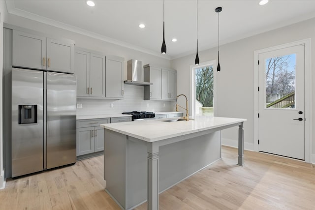 kitchen featuring stainless steel refrigerator with ice dispenser, gray cabinetry, range, a sink, and wall chimney exhaust hood