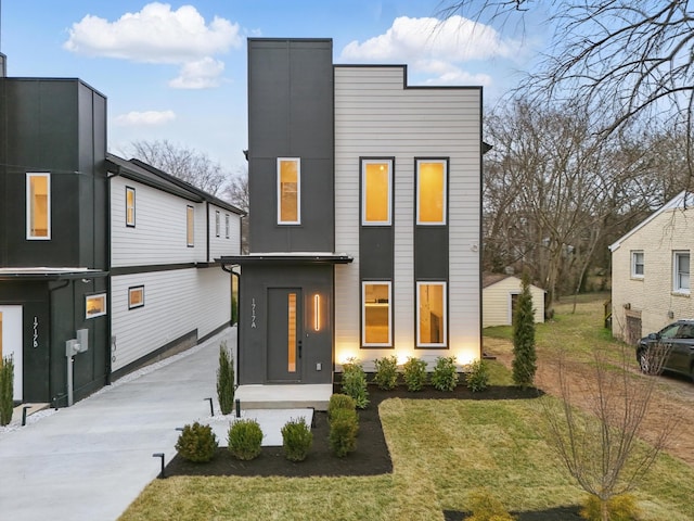 contemporary home with driveway and a front lawn