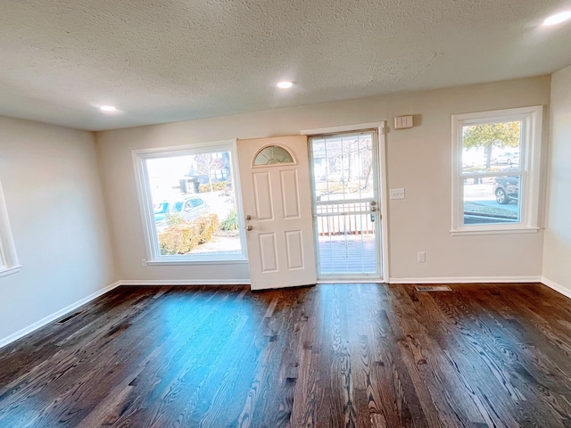 entryway featuring a textured ceiling, visible vents, dark wood-style flooring, baseboards, and recessed lighting