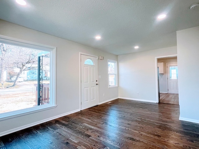 foyer featuring recessed lighting, dark wood finished floors, baseboards, and a textured ceiling