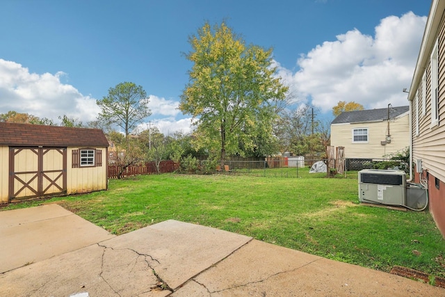 view of yard with a storage shed, a patio, central AC, a fenced backyard, and an outbuilding