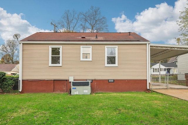 back of house with a yard, fence, crawl space, an attached carport, and a gate