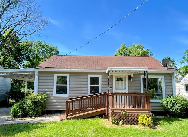 rear view of property with roof with shingles and a deck