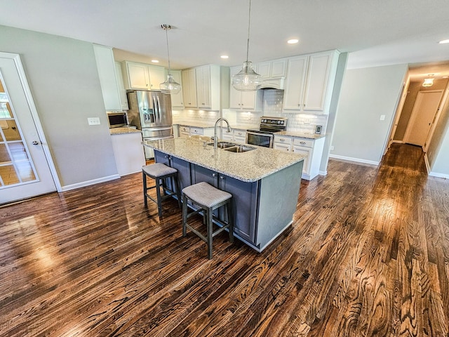 kitchen with a sink, tasteful backsplash, a kitchen bar, stainless steel appliances, and dark wood-type flooring