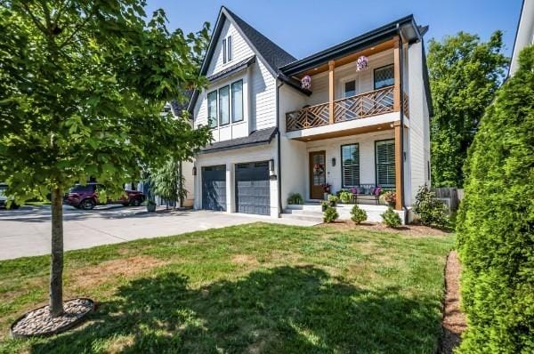 1412 Woodmont Blvd, Nashville, TN 37215 - view of front facade with covered porch, a garage, driveway, a balcony, and a front lawn